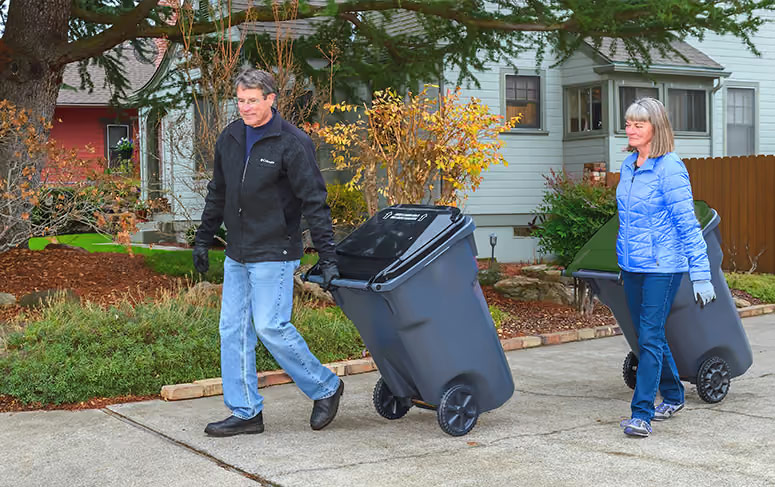 Residents rolling waste carts to the curb for collection